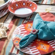 a place setting with napkins, silverware and other decorative items on the table