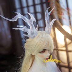 a doll with white hair and horns on it's head is posed for the camera