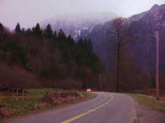 an empty road with mountains in the background