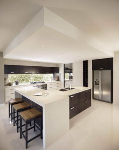 a large kitchen with an island counter and stools