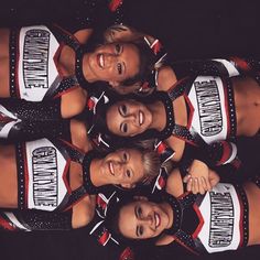 a group of women standing next to each other in front of a black background wearing cheerleader outfits