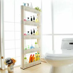 a bathroom with a toilet, sink and shelves on the wall next to the window