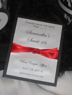 a black and white wedding card with red ribbon