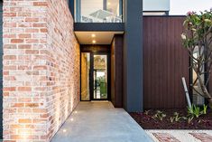 an entrance to a modern home with brick walls