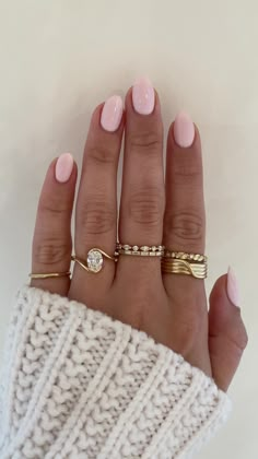 a woman's hand with three different rings on her fingers and one is wearing a sweater