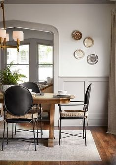 a dining room table with chairs and plates on the wall