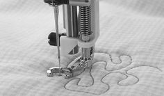 the sewing machine is being used to sew on some fabric or other material that has been stitched together