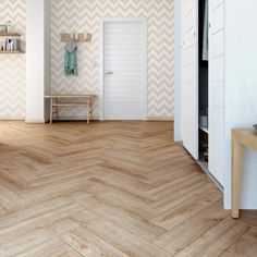 an empty room with wooden floors and chevron wallpaper