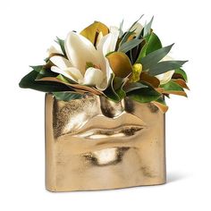 a gold vase with flowers in it on a white background