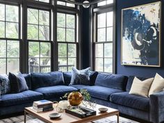 a living room filled with blue couches and windows