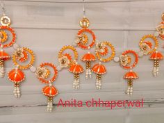 an assortment of orange and white beaded earrings hanging from a window sill with the words anta - chapetwal written on it