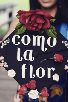 a woman holding up a graduation cap that says compo la flor