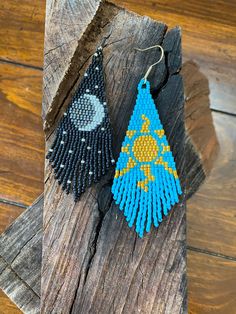 two pairs of beaded earrings sitting on top of a piece of wooden planks