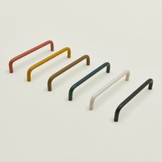 four different colored handles on a white surface