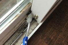 a person holding a toothbrush in front of a window with water damage on it