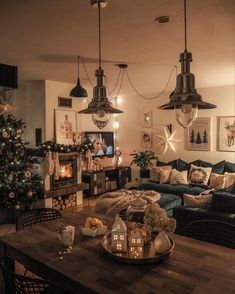 a living room filled with lots of furniture and lights hanging from the ceiling next to a fire place