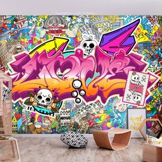 a living room with graffiti wallpaper and chairs