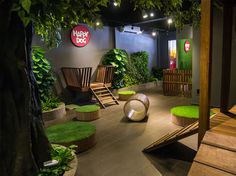 an indoor play area with artificial grass and wooden furniture