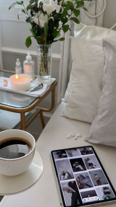 a cup of coffee sitting on top of a white table next to a tablet computer