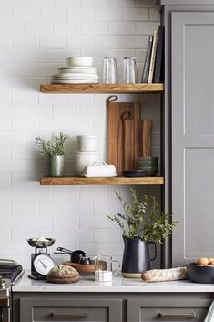 the kitchen is clean and ready for us to use it's shelves are filled with dishes