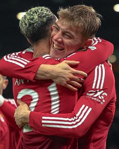 two soccer players are hugging each other and smiling