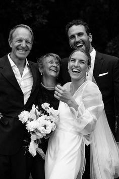 the bride and groom pose for a photo with their parents