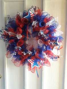 a red, white and blue wreath hanging on a door