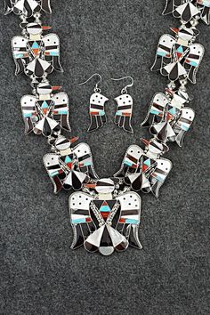 This stunning turquoise, onyx, mother of pearl, coral and sterling silver inlay necklace and earrings set was made by Zuni silversmith Bobby Shack. The set is signed B&C Shack, Zuni and Sterling. Necklace: 26" Pendant Length: 2 1/2" Pendant Width: 2 1/4" Earrings: Length: 1 7/8" Width: 1/2" Bracelet: Size: 5" (will fit up to a 6 3/8" wrist) Gap: 1 3/8" Width: 1 5/8" Free shipping on all orders! We ship with USPS and always include tracking. All orders ship within a day of payment. Returns are accepted up to 30 days after you receive your order. Just send us a message. Our shop offers cash back or store credit. The item must be returned in new condition. Southwestern Silver Jewelry With Inlay, Sterling Silver Jewelry With White Inlay, White Sterling Silver Jewelry With Inlay, Southwestern Silver Necklaces With Inlay, Southwestern Jewelry With Inlay For Gifts, Southwestern Style Jewelry With Inlay For Gift, Southwestern Black Sterling Silver Jewelry, Artisan Multicolor Jewelry With Inlay, Traditional White Jewelry With Inlay