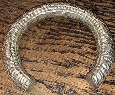 Superb late 19th century Chinese wedding bracelet, silver metal over unknown core, circa 1890s, w dragons, chrysanthemums, and the good luck Chinese symbol, shou coin. Nice weight and authentic period piece. The bracelet has an opening making it fit medium to large wrists. Fine detail, nice warm patina, unpolished, lovely. Sold as found. View all photos and zoom in for details. It's assumed you've read the description and viewed all photos before purchase. Victorian Brass Silver Bracelets, Antique Silver Brass Bracelet, Silver Brass Bracelets Hand Cast, Antique Silver Hand-cast Bracelets, Antique Silver Hand Cast Bracelets, Ceremonial Silver Brass Bracelets, Silver Spiritual Brass Bangle, Spiritual Silver-colored Brass Bangle, Silver Brass Cuff Bracelet For Wedding