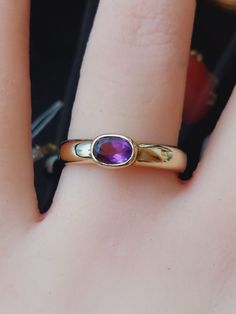 A beautifully made unusual vintage ring featuring an oval cut natural amethyst gemstone. The ring is of lovely quality and is a substantial weight, it is being offered in excellent vintage condition. The ring is fully hallmarked for 9ct yellow gold. Weight 3.6g Approx 0.50 carats amethyst  Ring size O US size 7 Thank you for choosing Carriesclocks! Buying antique and vintage jewellery is both ethical and eco-friendly! Classic Amethyst Oval Cabochon Ring, Oval Amethyst Ring Stamped 14k, Classic Amethyst Ring Stamped 14k, Hallmarked Oval Cabochon Amethyst Ring, Purple Oval Cabochon Hallmarked Ring, Classic Oval Purple Amethyst Ring, Classic Amethyst Oval Cabochon Ring As Gift, Classic Oval Amethyst Crystal Ring, Classic Oval Amethyst Ring