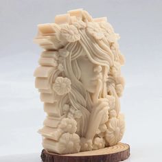 a carved ivory figurine sitting on top of a wooden stand