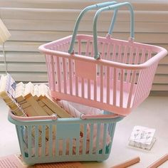 a pink and blue basket sitting on top of a desk next to a pile of books