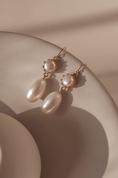 The design of Mira features a freshwater drop pearl suspended from a pearl encased in a 14k gold-filled bezel cup.The gold hook on these earrings is extra fine and comfortable to wear.  A timeless and versatile accessory, these earrings are suitable for any occasion, from formal events to casual outings. Packaged in an elegant plastic-free reusable jewelry box, they make the perfect gift or special treat for oneself.  14k gold-filled components Freshwater pearls Hypoallergenic, suitable for even Classic Pearl Drop Earrings For Everyday Elegance, Classic Teardrop Pearl Earrings For Everyday Elegance, Classic Teardrop Pearl Earrings For Everyday, Everyday Classic Teardrop Pearl Earrings, Classic Pearl Pendant Earrings In 14k Gold Filled, Elegant 14k Gold Filled Dangle Teardrop Earrings, Elegant 14k Gold Filled Teardrop Earrings, Elegant Rose Gold Earrings For Everyday Elegance, Classic 14k Gold Filled Earrings With Pearl Charm