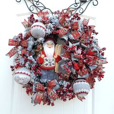 a christmas wreath with santa clause and ornaments hanging on the front door ornament