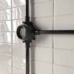 a black and white photo of a shower head in a bathroom with tile on the walls