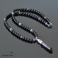 The centerpiece of this long gemstone men's necklace is an Amethyst healing point pendant. The combination of black matte onyx and shiny purple striped amethyst beads creates balanced, manly and sophisticated look. This piece is perfect for making a statement effortlessly and stylishly. This necklace is strung on a beaded wire and finished off with a lobster claw clasp. You can select the necklace length from the drop-down menu on the right. The pendant measures approximately 2.36 inches long (6 Necklace For, Mens Beaded Necklaces, Tigers Eye Necklace, Amethyst Healing, Healing Crystal Jewelry, Jewelry For Men, Necklace For Men, Amethyst Beads, Necklace Long