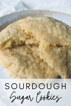 two sugar cookies on a white plate with the words, sourdough sugar cookies