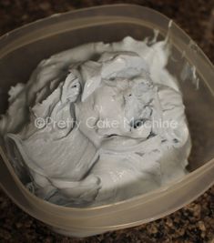 a plastic container filled with white frosting on top of a counter