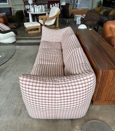 a living room filled with furniture and lots of chairs on top of carpeted flooring