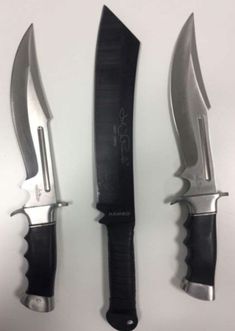 three knives with black handles are on display