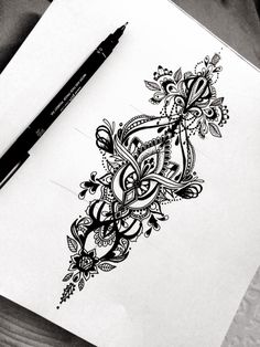 a pen is sitting on top of a piece of paper that has an intricate design