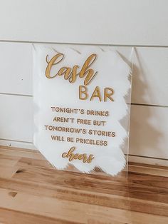 a sign that says cash bar on the side of a wooden floor next to a plant