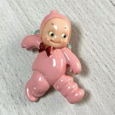 a pink baby doll with a bow on its head