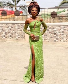 a woman in a green dress posing for the camera with her hand on her hip