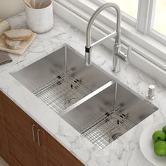 two stainless steel sinks in a kitchen with marble counter tops