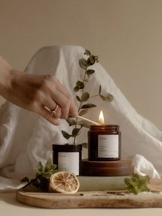 a person lighting a candle on top of a cutting board next to a lemon slice