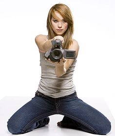 a woman sitting on the floor holding a camera