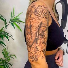 an elephant and flowers tattoo on the arm