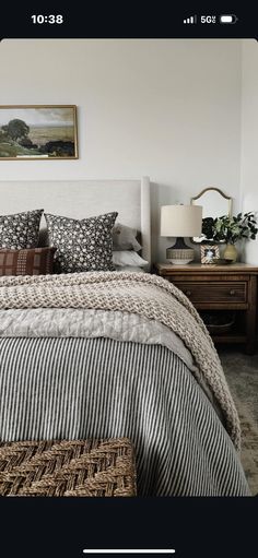 an image of a bedroom setting with bed, nightstands and pictures on the wall