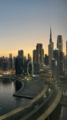 the city skyline is lit up at night with cars driving on it's highway